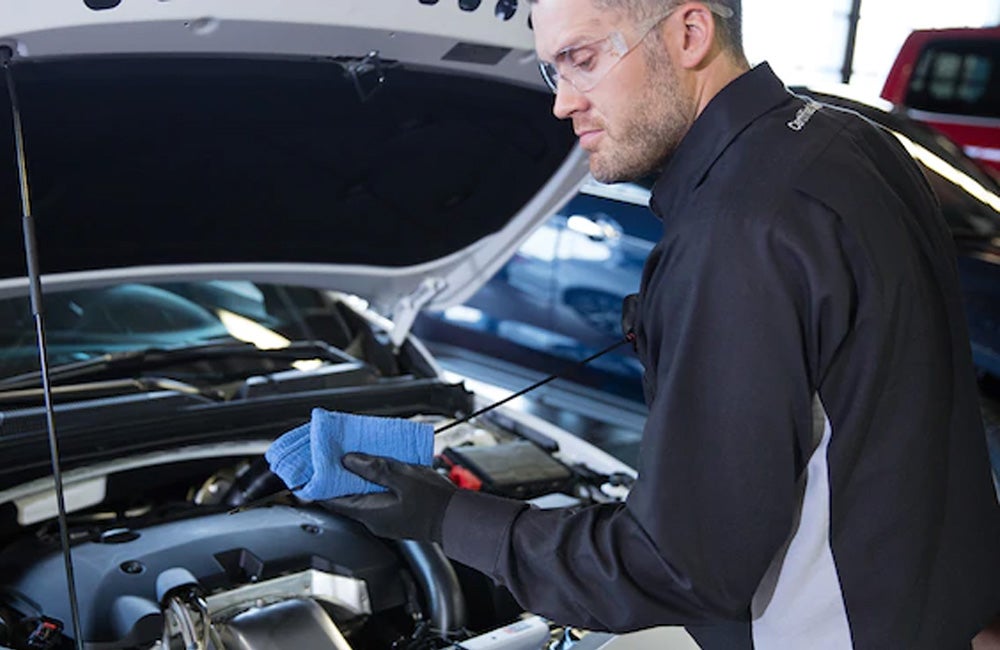 A man examines a car engine